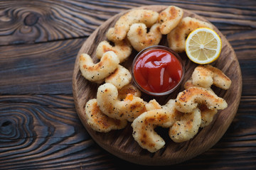 Rustic wooden serving board with fried breaded shrimps