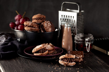 Almond cookies and chocolate milkshake on dark wooden background