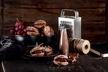 Organic almond cookies on dark wooden background with chocolate