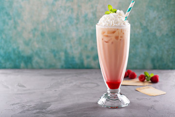 Iced milkshake with raspberry syrup and whipped cream