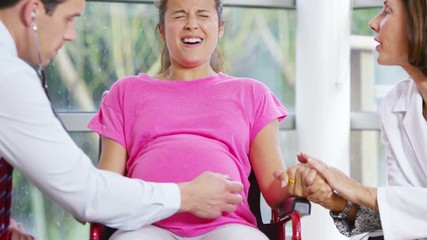 Pregnant woman going into labour concentrates on her breathing - Powered by Adobe