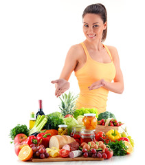 Young woman with variety of organic grocery products on white