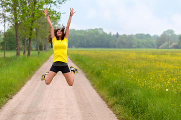 Fototapeta premium Energetic agile young woman leaping for joy