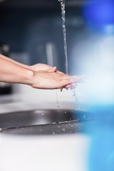 Woman cleaning hands in kitchen at home
