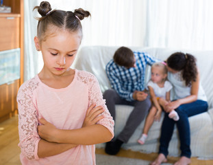 girl sad because of jealous younger sister to parents - obrazy, fototapety, plakaty