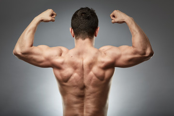 Bodybuilder model back on gray