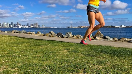 Woman running along urban waterfront, San Diego, California, USA