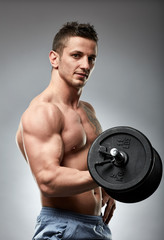 Biceps curl with dumbbell on grey background