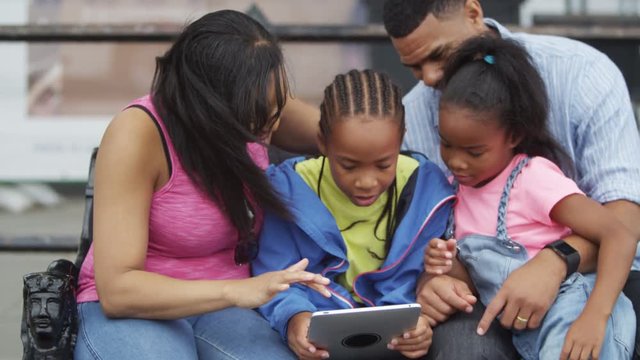  Happy African American family in the city looking at computer tablet. Shot on RED Epic