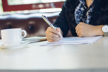 Fototapeta na wymiar close up of business woman hand writing on a paperwork