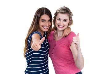 Obraz na płótnie Canvas Portrait of happy female friends showing thumbs up