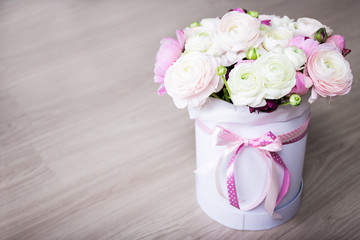 big bouquet of summer flowers in white round box on wooden table