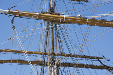Mast of the sailing boat, blue sky in the background.