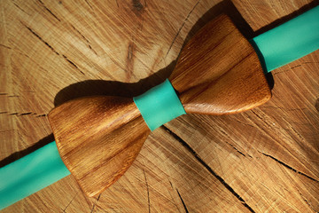 Wooden bow tie with ribbon mint colour lay on dry wood background. Diagonal line, flat lay. Natural...