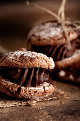 Maroni cookies with pieces of chocolate on old wooden background