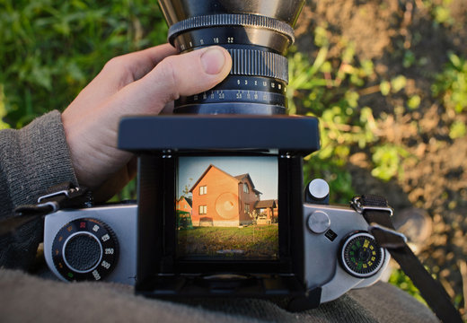 man photographer is making architecture photography with old film  camera