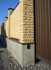 New modern yellow high metal fence in early spring