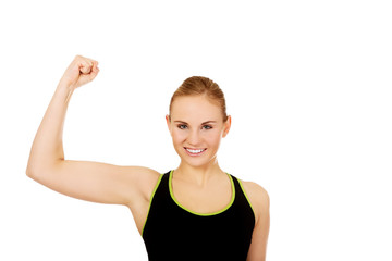 Fototapeta premium Young athletic woman showing muscles