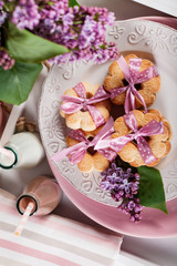 Butter cookies with pink ribbon,lilac flowers and chocolate milk