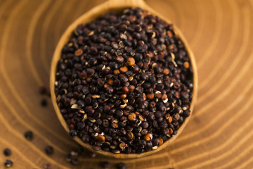 Black quinoa seeds on a wooden background