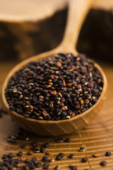 Black quinoa seeds on a wooden background