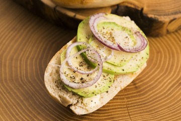 Sandwich with avocado, red onion, salt and herbs