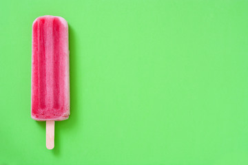 Strawberry popsicle on green background
