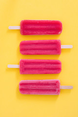 Strawberry popsicle on yellow background
