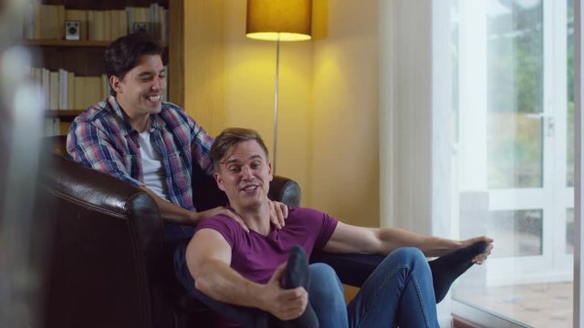  Attractive young gay couple relaxing at home and chatting