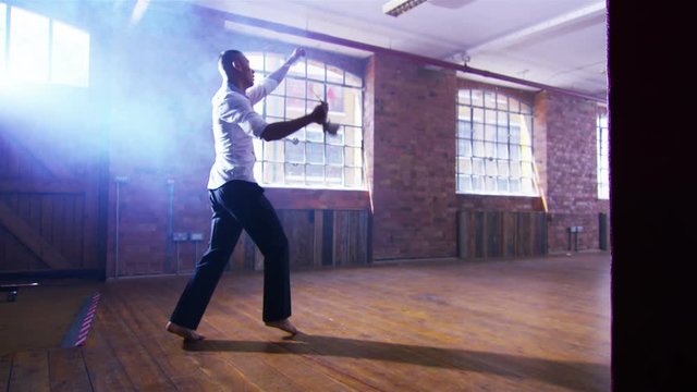  Asian martial artist training alone, practising moves with shaolin whip chain