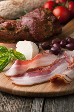 Smoked bacon with bread, mozzarella, olives and basil