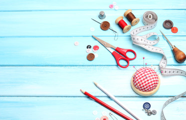 tools tailor spools threads buttons needle sewing  blue wooden background
