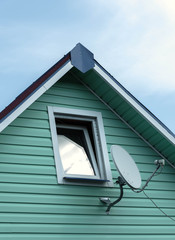 Satellite dish on a wall of wooden village house