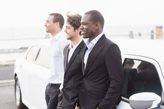 Well Dressed Men Posing Leaning On A Limousine