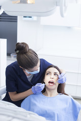 Beautiful woman patient having dental treatment at dentist's office. Women dentist