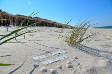 Wir haben Urlaub Text im Sand