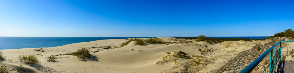 Panorama of sandy dunes and blue sky in the spring morning. Efa Height., Curonian Spit National Park, Russia.