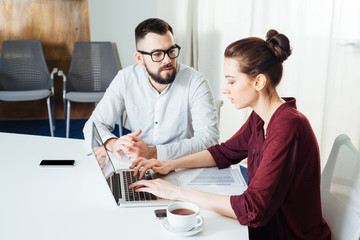 Two businesspeople typing on laptop and working together