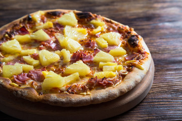 Hawaiian pizza on a wooden table