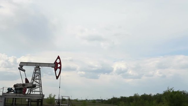the oil pump is pumping oil. Cloudy sky.