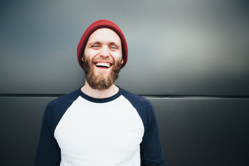 Hipster man smiling and wearing a hat - obrazy, fototapety, plakaty