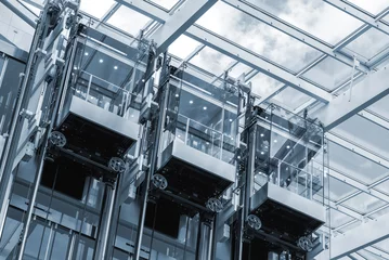 Photo sur Plexiglas construction de la ville Trois ascenseurs dans un centre d& 39 affaires moderne. Photographie colorisée en bleu