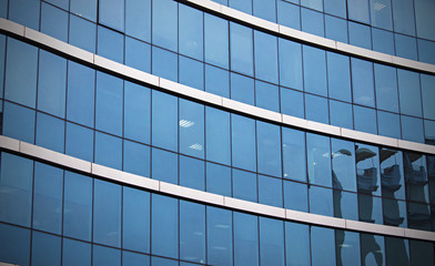 skyscraper building windows and sky reflection in windows