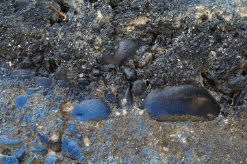 Dirty grey concrete wall with blue colored stones 9