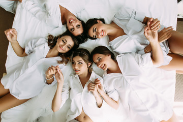 Girls with a bride are lying in the circle