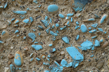 Dirty grey concrete wall with blue colored stones 6