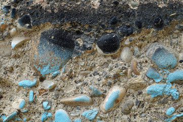 Dirty grey concrete wall with blue colored stones 5