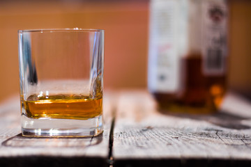 Whiskey auf rustikalem Holzuntergrund mit Flasche