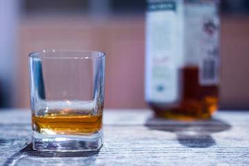 Whiskey auf rustikalem Holzuntergrund mit Flasche