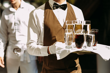 Waiter is holding a server with the champagne